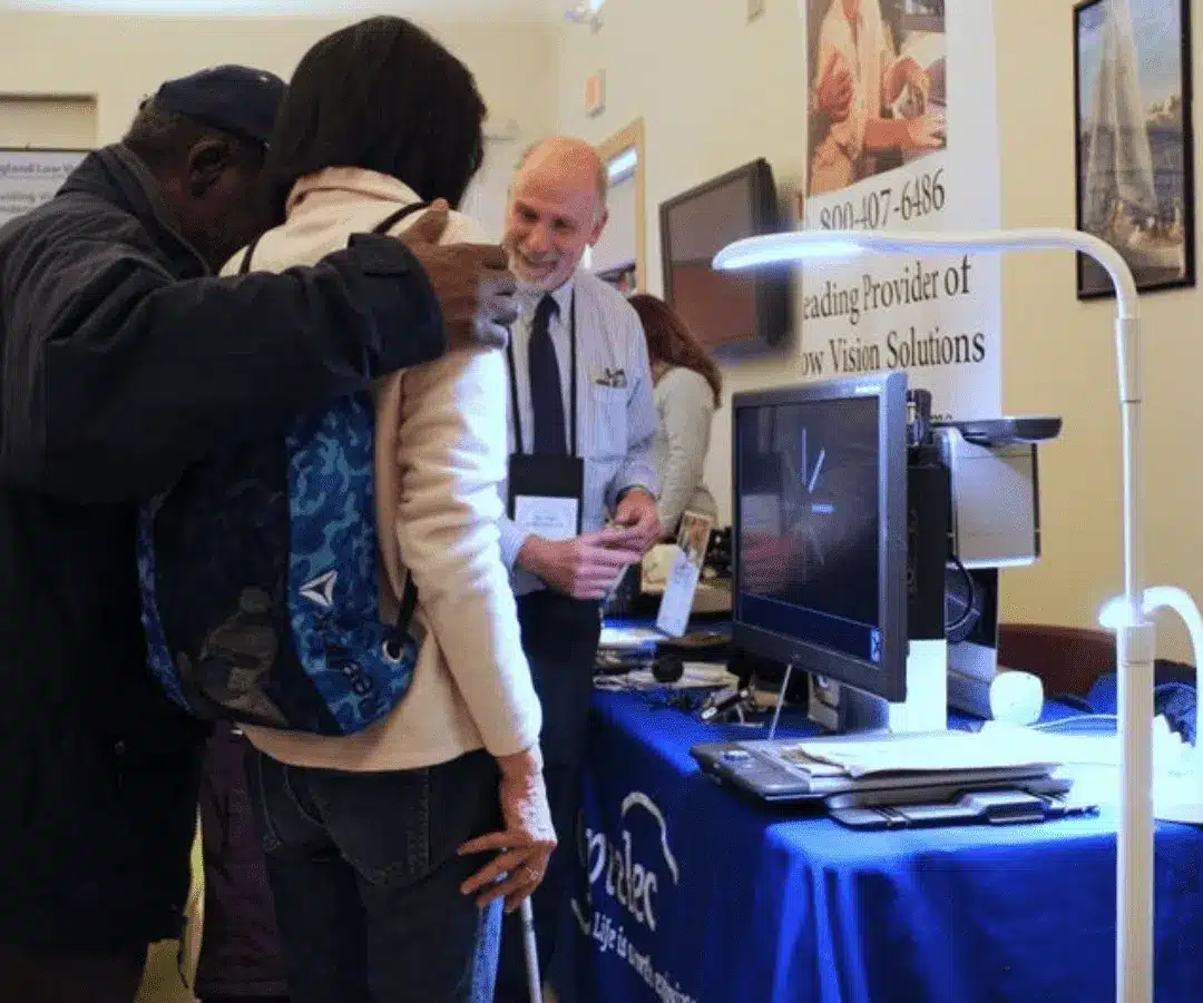 Stu Flom chatting with people at technology fair for low vision and blindness