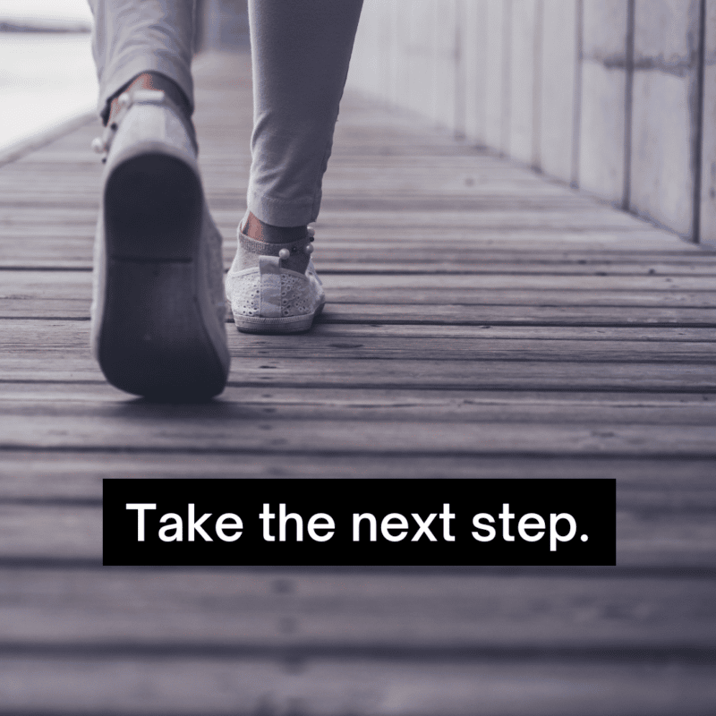 Closeup of the feet of a person walking with text, "Take the next step."