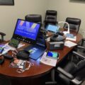 Conference table and chairs showing an array of assistive technology for low vision and blindness