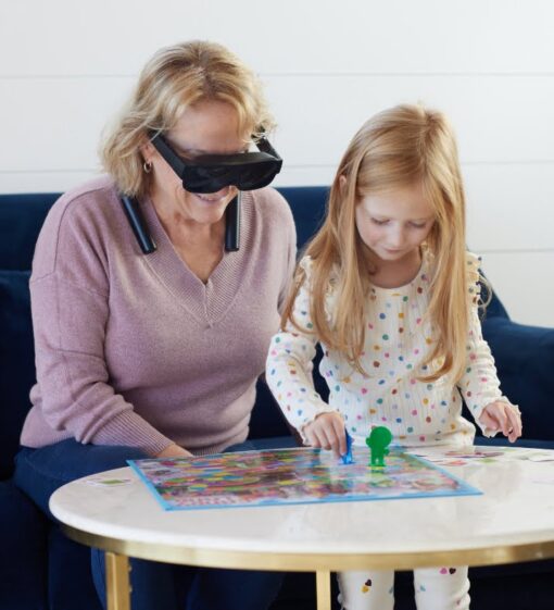 Person reading with child wearing eSight go