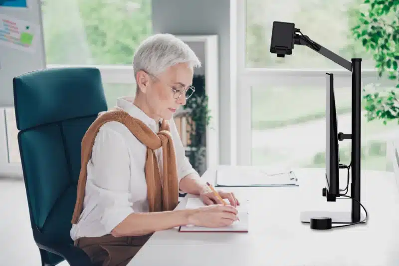 Luna Eye in use by someone writing at a desk, profile view